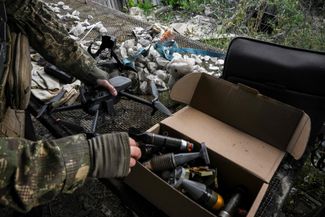 Ukrainian soldiers prepare munitions for a small drone. September 2022