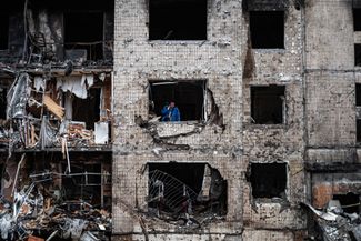 Мужчина в окнах многоквартирного дома в Соломенском районе Киева ищет, по предположению авторов снимка, необходимые документы в уничтоженной квартире. На фотографии изображен один из двух домов, в наибольшей степени пострадавших в результате удара.