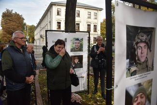 Женщина плачет у портретов пленных и пропавших без вести украинских военнослужащих. Эти снимки установлены на одной из площадей Львова по инициативе жен бойцов 24-й отдельной механизированной бригады ВСУ