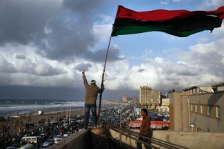 24 февраля 2011 года. Протестующие в Бенгази со старым флагом Ливии, запрещенным в правление Каддафи. Оно началось в 1969 году