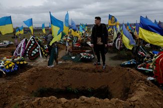 Руслан Бурменко у могилы своего брата Романа Бурменко. Он погиб в возрасте 31 года, помогая раненым солдатам во время боя в Бахмуте