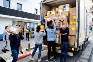 Добровольцы израильской организации «Друзья Украины» загружают ящики с гуманитарной помощью в грузовик. Тель-Авив, 3 марта 2022 года