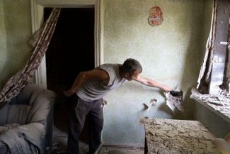 Житель Бахмута осматривает свой дом после обстрела российскими войсками
