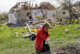 Женщина плачет у своего дома в селе Ольховка, которое расположено в 24 километрах от Харькова