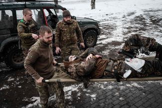 Парамедики несут украинского военнослужащего, который наступил на мину. <br>