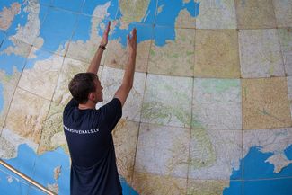 Айварс Белдавс показывает глобус, составленный из рельефных топографических карт масштаба 1:1000000