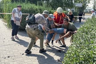 Волонтеры помогают транспортировать раненую в результате ракетного удара по Харькову 1 сентября. Всего в результате обстрела в этот день в Харькове пострадали более 40 человек