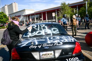 Демонстранты пишут лозунги «Покойся с миром, Джордж» и «Не могу дышать» — последние слова Джорджа Флойда, которые он успел произнести перед смертью от удушения при задержании полицией. Миннеаполис, штат Миннесота, 28 мая 2020 года