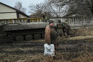 Жительница Бахмута на фоне украинской военной техники