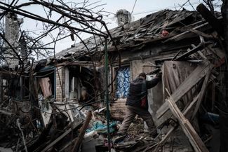 В дом 73-летнего Александра Пыхтина во время обстрелов попала ракета. На фото он пытается открыть уцелевший холодильник