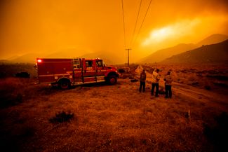 Пожарные наблюдают за горящим лесом в местности Джунипер-Хиллс к северо-востоку от Лос-Анджелеса. 17 сентября 2020 года