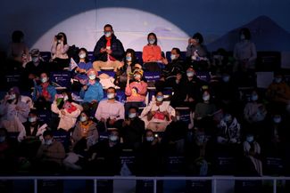 Олимпийские трибуны во время соревнований по керлингу. Зрители, чтобы получить возможность наблюдать за игрой, обязаны носить респираторы класса FFP2. 8 февраля 2022 года.