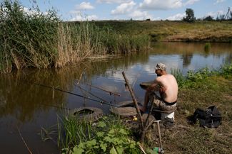 Украинский военнослужащий во время отдыха ловит рыбу в районе прифронтового Бахмута, Донецкая область