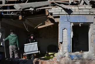 Жители Камышевахи Запорожской области выносят вещи из своего дома, поврежденного при ночном ракетном обстреле