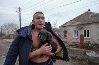 Житель Мариуполя с собакой на руках после обстрела 24 февраля 2022 года