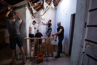 Жители пострадавшего дома в Киеве убираются на чердаке