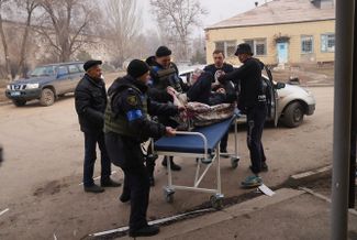 Украинские военные и волонтеры спасают раненного во время обстрела больницы № 3 в Мариуполе