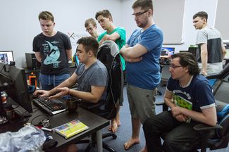 Тренер команды Алексей Таранда (сидит за компьютером) разбирает с командой одну из игр в тренировочном доме