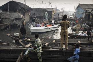 Категория «Проблемы современности», первое место в номинации «Отдельная фотография». Туристы путешествуют по каналам в Макоко — рыбацкой деревне, разросшейся до огромного поселения, в крупнейшем городе Нигерии Лагосе, 24 февраля 2017 года