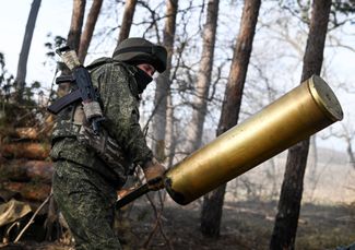 Российский военный несет гильзу от снаряда «Гиацинт-Б» на огневой позиции