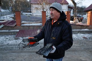 Житель села Старые Безрадичи показывает обломки российского дрона-камикадзе