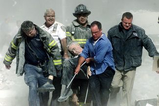 Спасатели выносят из-под завалов капеллана нью-йоркского пожарного департамента Михала Джаджа. Джадж погиб 11 сентября от полученных травм