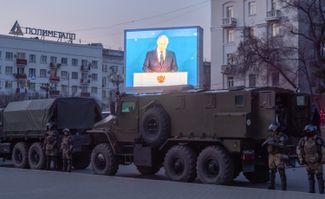Полиция готовится к акции протеста, пока на больших экранах транслируют обращение Владимира Путина.
