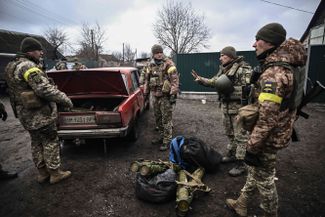 Ukrainian soldiers disassemble weapons that were brought to them in an old Zhiguli sedan