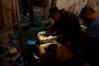 Хирург украинской армии осматривает раненого