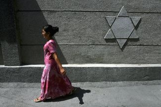 An Uzbek woman passes the only remaining synagogue in Fergana, Uzbekistan. August 14, 2006.
