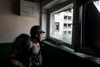 Украинский связист перед установкой антенны в квартире многоэтажного дома недалеко от Бахмута