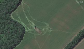 Спутниковый снимок поля, на котором видны полевые реактивные системы залпового огня (РСЗО), направленные в сторону Северодонецка. За одной из РСЗО видны следы ожогов на земле, это может быть признаком недавней стрельбы.