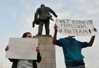 Protesters in Vladivostok standing behind a monument to Bolshevik revolutionary Vladimir Lenin.