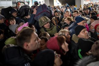 A Ukrainian soldier attempts crowd control at a train station in Lviv.