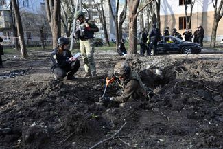 Украинские саперы обследуют место взрыва, появившееся в результате воздушного удара по Харькову в ночь на 6 апреля