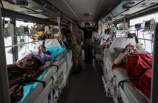 Волонтеры украинской добровольческой организации парамедиков «Госпитальеры» эвакуируют украинских военных, раненых в Бахмуте. Их везут в больницу в Днепре. 8 мая 2023 года