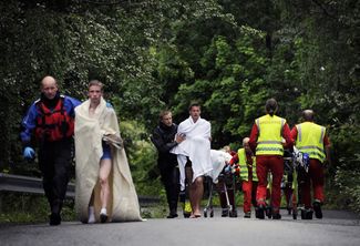 Спасатели ведут пострадавших в результате стрельбы на острове Утойя, 23 июля 2011 года
