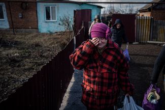 A resident of the Minkovka village is crying as she leaves her house.  From Minkovka to Bakhmut about 15 kilometers