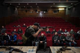 Ukrainian volunteers learn how to handle weapons in a movie theater in Lviv.