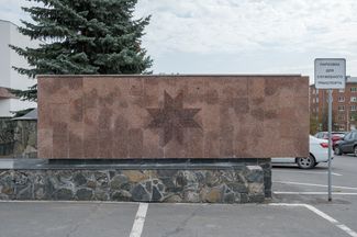 The parking lot outside Udmurtia’s State Council building, which features a wall decorated with a symbol of the sun. September 2019