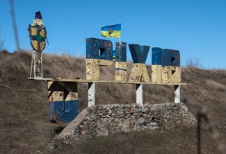 Поврежденный обстрелами знак с названием города при въезде в Орехов