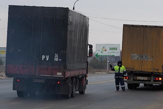Police inspect heavy trucks headed for Moscow.
