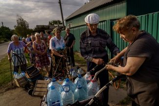 Жительница города Константиновка наполняет принесенные соседями бутылки водой из своего источника. Женщина занимается этим два часа в день. Для многих жителей города ее источник — единственная возможность получить чистую воду