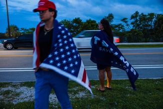 Сторонники Дональда Трампа молятся возле его резиденции Мар-а-Лаго в Палм-Бич, штат Флорида. 13 июля 2024 года