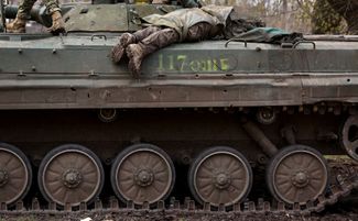 Бойцы ВСУ перевозят на танке тело товарища, погибшего в бою рядом с Часовым Яром — городом в 13 километрах от Бахмута, через который проходит ключевая линия снабжения украинских подразделений на этом направлении