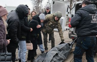 Местные жители помогают опознать тело одного из погибших в результате ракетного удара по Запорожью