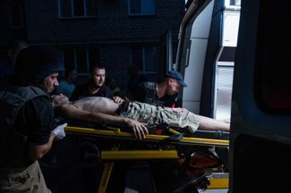 Парамедики несут раненого мужчину в отделение неотложной помощи в Бахмуте