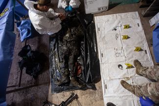 Bridgehead volunteers try to identify the deceased Russian soldier through items found on him. 