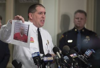 Шериф округа Бэрон Крис Фицжеральд показывает журналистам фотографию подозреваемого в убийстве и похищении Джейка Паттерсона, 11 января 2019 года