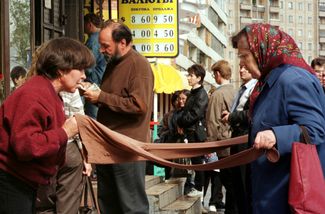 Очередь у пункта обмены валют. Пожилая женщина покупает колготки с рук рядом с очередью. 26 августа 1998-го.